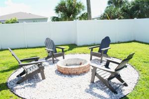 tre sedie sedute intorno a un focolare in un cortile di Port Charlotte Oasis House and Bunkhouse Pool, Hot Tub, RV Boat space a Port Charlotte