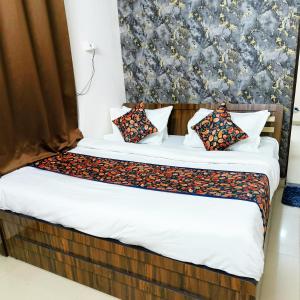 Un dormitorio con una cama con sábanas y almohadas blancas. en SR Elite Stays, en Jaipur 3 fotos más