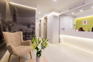 a waiting room with a chair and a woman in the background at Ringo Apartments in Podstrana