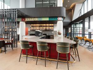 a bar with chairs and a counter in a restaurant at Novotel Devonport in Devonport