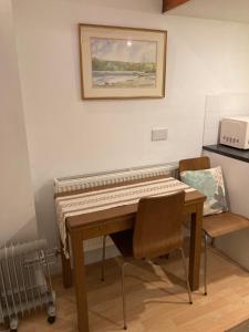 a piano in a room with a table and a chair at Studio Annexe with separate shower room in Broadhempston