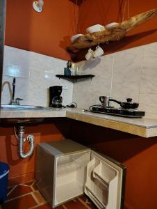 Una pequeña cocina con fregadero y estufa. en Zentroa habitación Senderos, en Villa de Leyva 1 foto más