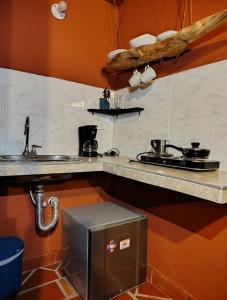 Una cocina con encimera con fregadero y estufa. en Zentroa habitación Senderos, en Villa de Leyva