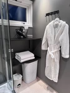 a bathroom with a shower and a white robe at Nordic villa with outdoor jacuzzi and Aurora Borealis view 