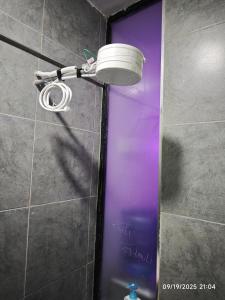 a bathroom with a shower with a bucket on the wall at Tsavo Stanley in Kiambu +34 photos