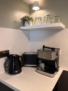 a kitchen counter with a coffee maker and a coffee pot at Little House Harrogate in Harrogate +8 photos