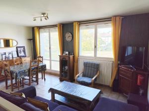 a living room with a tv and a table and chairs at Maison 3 chambres Le Mans, proche circuit in Le Mans