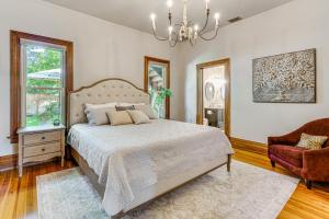 a bedroom with a bed and a chair and a chandelier at Downtown Walkability! Historic Home in Berthoud in Berthoud