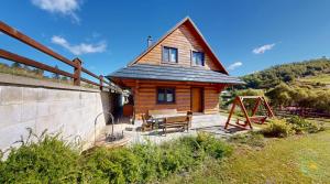 a small wooden house with a picnic table in front of it at Roháčske zruby 2,3,4 in Zuberec