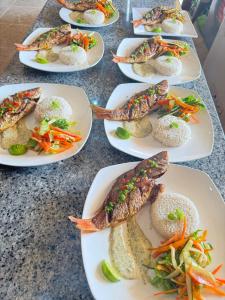 a table topped with plates of food with fish at Tubazenika Paradise Lodge - San blas in Tupile