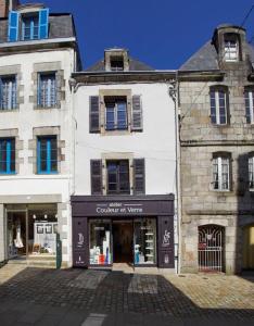 Ein weißes Gebäude mit einem Laden davor. in der Unterkunft Chez Nolwenn in Quimper