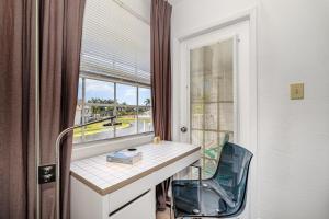 メルボルンにあるBright King Bed Escape Pondview Half mile to Beachのデスク、椅子、窓が備わる客室です。 +20枚の写真