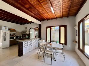 a kitchen with a table and chairs and a refrigerator at Casa de Vó in Porto Seguro