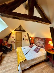 ein Schlafzimmer mit einem großen Bett im Dachgeschoss in der Unterkunft Logement à thème médiéval avec balneo in Sens