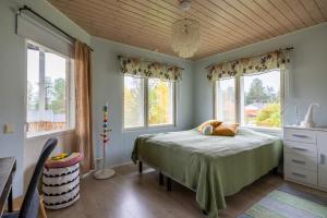 RovaniemiにあるVilla Welcome to Laplandのベッドと2つの窓がある寝室
