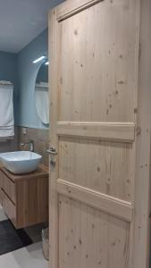 a bathroom with a wooden door with a sink at Il Nocciolo in Gaiola +9 photos
