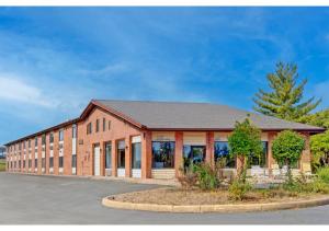 a large brick building with a parking lot at Capital O Amerihost Inn and Suites Fulton Hwy 54 MO in Fulton