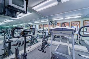 a gym with rows of exercise bikes and a tv at Capital O Amerihost Inn and Suites Fulton Hwy 54 MO in Fulton