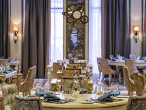 a dining room with a table and chairs and a clock at Rixos Premium Seagate in Sharm El Sheikh +97 photos