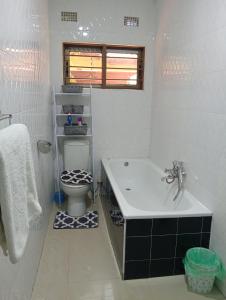 a white bathroom with a toilet and a sink at 3 bdr apartment with Solar Backup & Wi-Fi Salama in Lusaka +48 photos