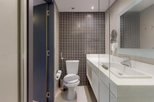 a white bathroom with a toilet and a sink at 1164 Helbor Stay Batel, Conforto e Estilo no Coração de Curitiba in Curitiba