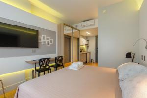 a bedroom with a bed and a table and chairs at 1164 Helbor Stay Batel, Conforto e Estilo no Coração de Curitiba in Curitiba