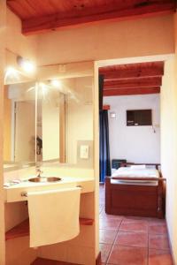a bathroom with a sink and a bedroom with a bed at Costa Bonita Aparts & Spa in Villa Carlos Paz