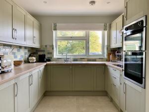 a kitchen with white cabinets and a window at 5 Bed in Washbrook oc-m33105 in Hintlesham