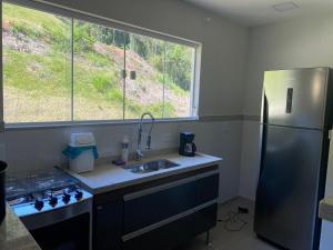 a kitchen with a sink and a refrigerator at EuroPark no centro para casais e famílias, 800M da rua do lazer - incrível vista das montanhas in Domingos Martins