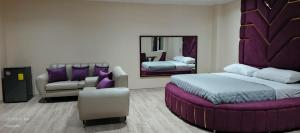 a bedroom with a bed and a chair and a mirror at Hostal Manhatan Condado in Quito