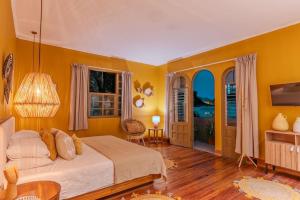 a bedroom with yellow walls and a bed and a table at awā San José in San José