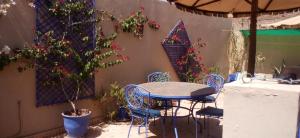 a patio with a table and chairs and a tree at Riad Jakoura in Marrakech