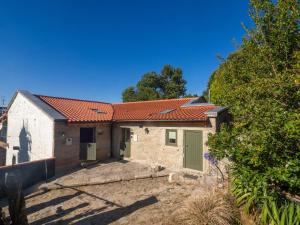 ein Haus mit rotem Dach und grünen Türen in der Unterkunft Castelo Gerês - Exquisite Eco-Cottage - jacuzzi in Lindoso