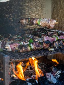 Ein Haufen Essen auf einem Grill mit Flammen in der Unterkunft Castelo Gerês - Exquisite Eco-Cottage - jacuzzi in Lindoso