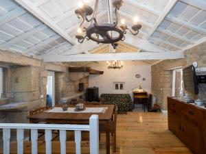 ein Wohnzimmer mit einem Tisch und einem Kronleuchter in der Unterkunft Castelo Gerês - Exquisite Eco-Cottage - jacuzzi in Lindoso