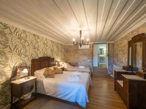 ein Schlafzimmer mit zwei Betten und einem Kronleuchter in der Unterkunft Castelo Gerês - Exquisite Eco-Cottage - jacuzzi in Lindoso