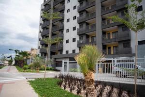 un condominio con recinzione bianca e piante di Moov Smart Home – Studios e Apartamentos por Temporada em Cuiabá a Cuiabá