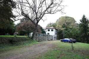 a blue car parked in front of a house at La Casa nel Bosco in Somma Lombardo