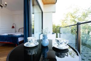 une pièce avec une table en verre avec deux tasses dessus dans l'établissement 7 Doors - Boutique Apartments in Kutaisi, à Koutaïssi