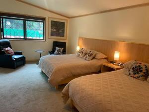 una stanza d'albergo con due letti e una sedia di Casa del Bosque - Huitzilac - Up to 24 guests a Huitzilac