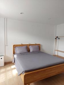 a bed with a wooden frame in a bedroom at Downtown Entire House - Mae Moli in Chiang Mai