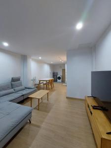 a living room with a couch and a flat screen tv at Downtown Entire House - Mae Moli in Chiang Mai