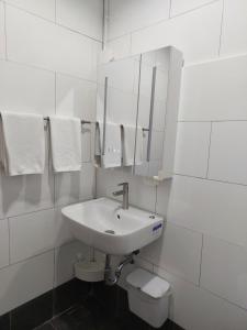 a white bathroom with a sink and a toilet at Downtown Entire House - Mae Moli in Chiang Mai +7 photos
