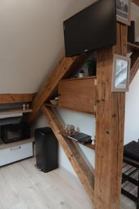 a living room with a tv on a wooden shelf at Cocon atypique proche centre historique Chambéry in Chambéry