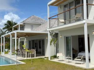 a house with a patio and a swimming pool at EAST KEYS - Villa Jamming, piscine à débordement et accès privé à la mer in Le Vauclin