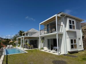 a large white house with a swimming pool at EAST KEYS - Villa Jamming, piscine à débordement et accès privé à la mer in Le Vauclin