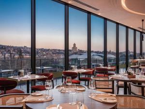 トビリシにあるSwissôtel Tbilisiの市街の景色を望むレストラン(テーブル、椅子付)