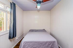 a bed in a small room with a ceiling fan at Casa Rosa Charmosa Completa BC Churrasco & Garagem in Balneário Camboriú