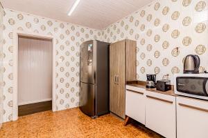 a kitchen with a stainless steel refrigerator and a microwave at Casa Rosa Charmosa Completa BC Churrasco & Garagem in Balneário Camboriú