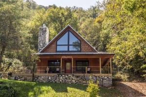 a cabin in the woods with a large window at A River Mist Walk in Sugar Grove